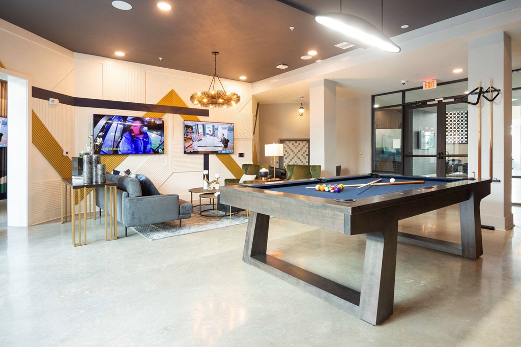 a game room with a pool table and a tv