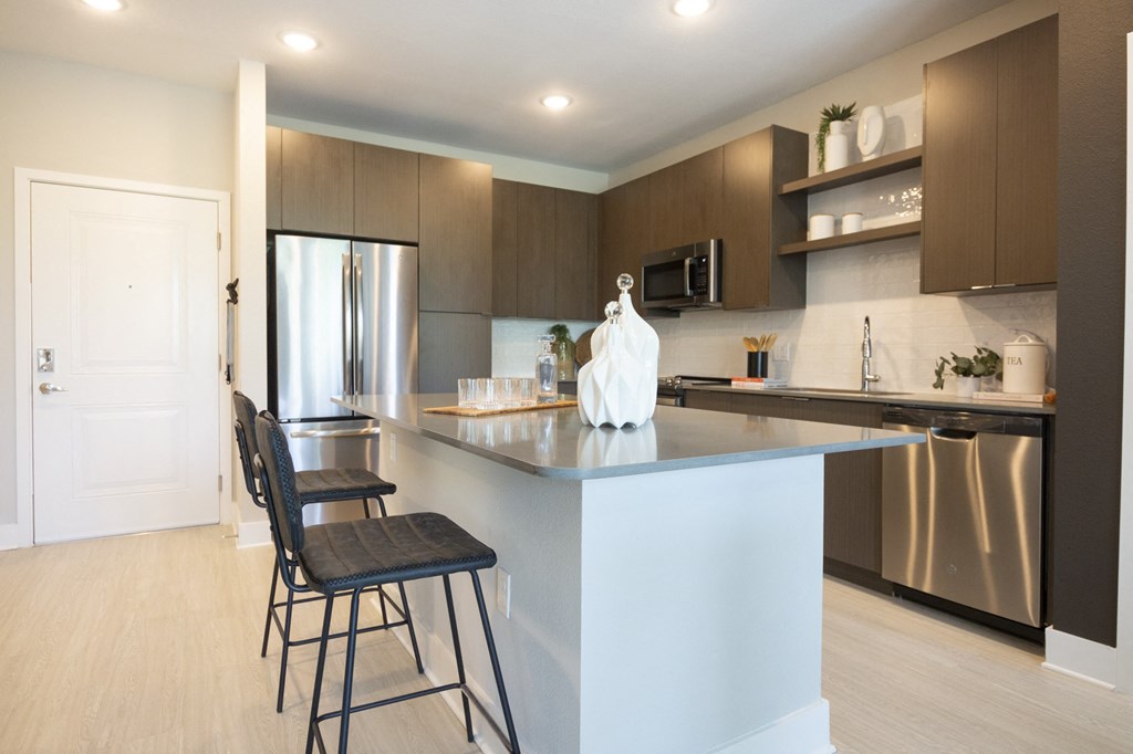 a kitchen with a large island with two bar stools