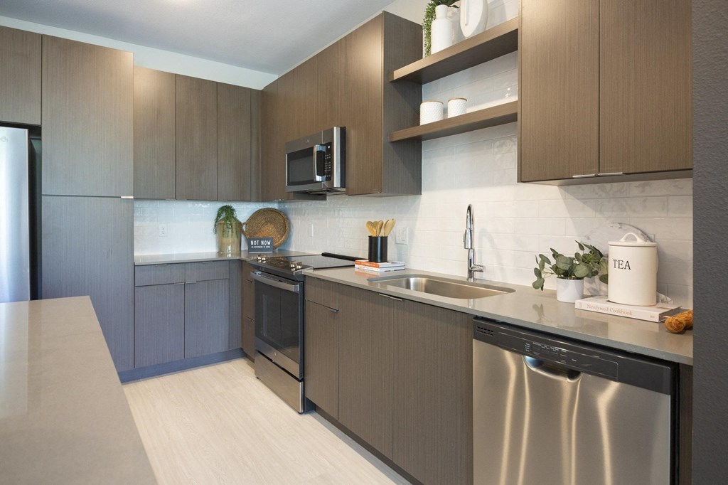 a modern kitchen with stainless steel appliances and wooden cabinets