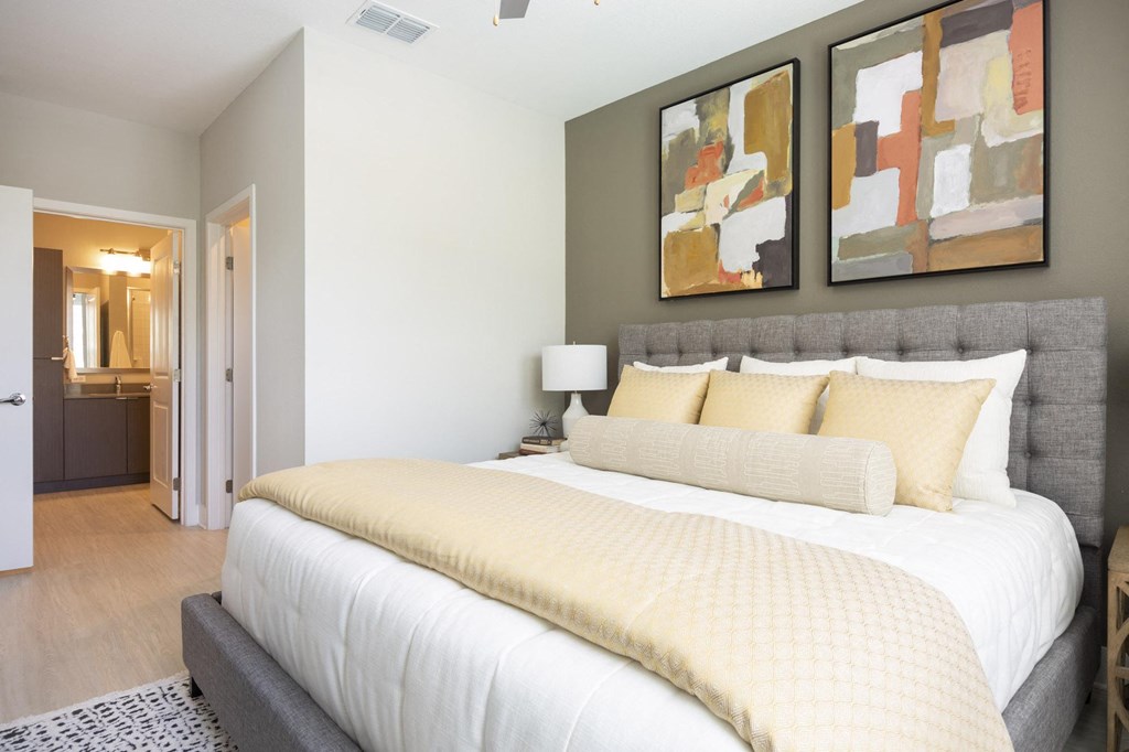 a bedroom with a large bed and paintings on the wall