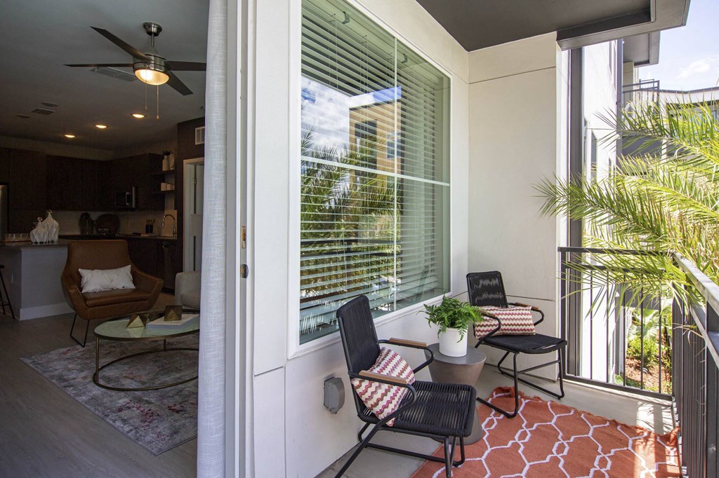 a patio with two chairs and a table and a window