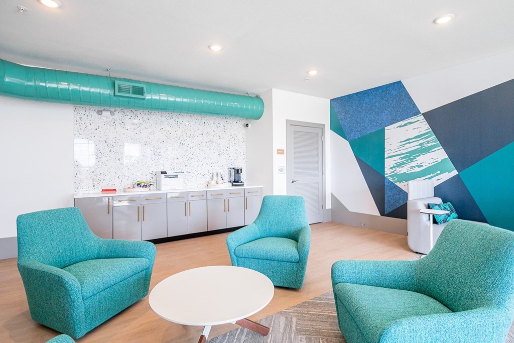a living room with blue chairs and a white table