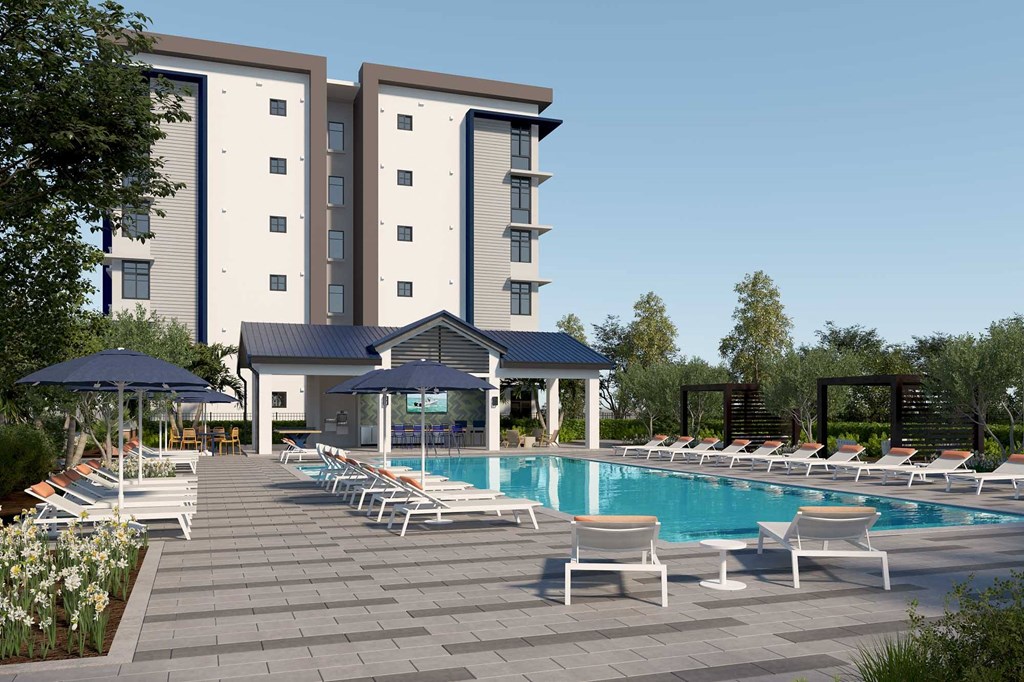 a swimming pool with chaise lounge chairs and umbrellas in front of a hotel