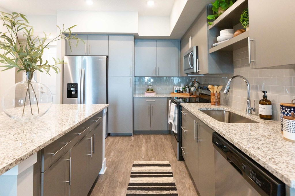 a modern kitchen with stainless steel appliances and marble counter tops