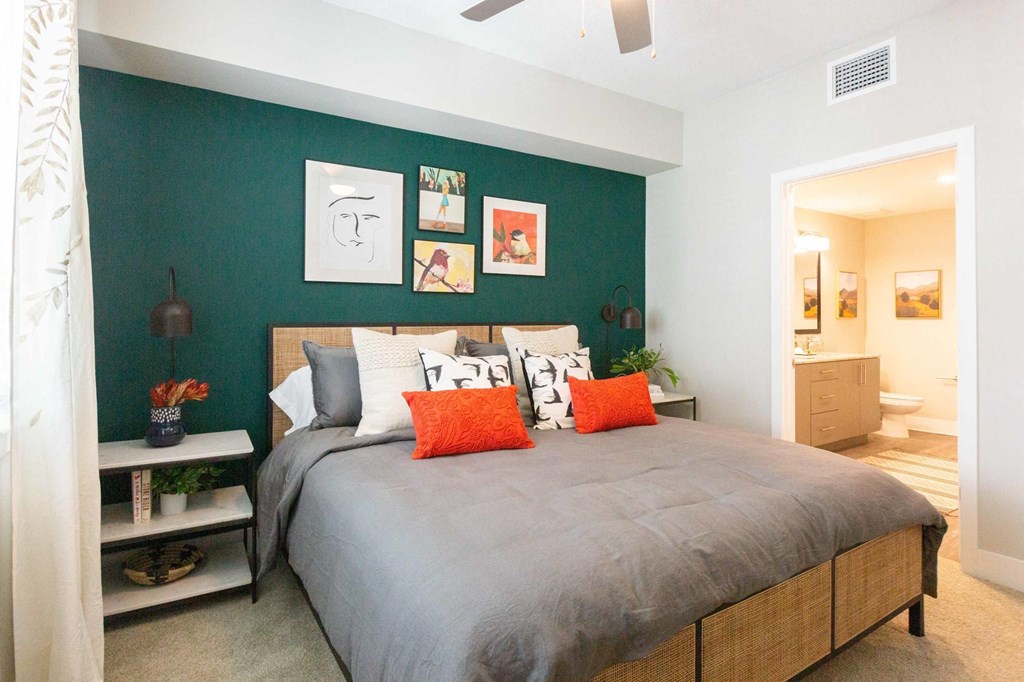 a bedroom with a large bed and a green accent wall