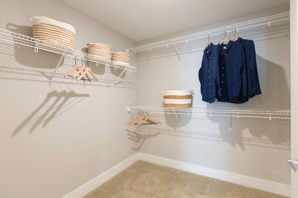 spacious closet with shelves and hangers with clothes and baskets in a manufactured home closet