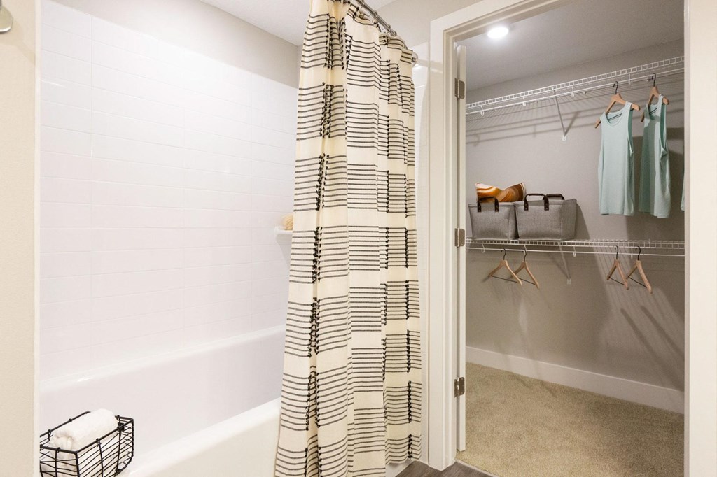 a bathroom with a shower and a closet with robes