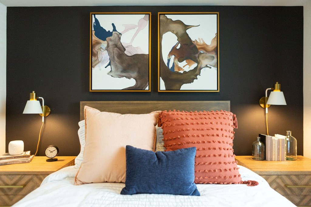 a bedroom with two paintings on the wall above a bed