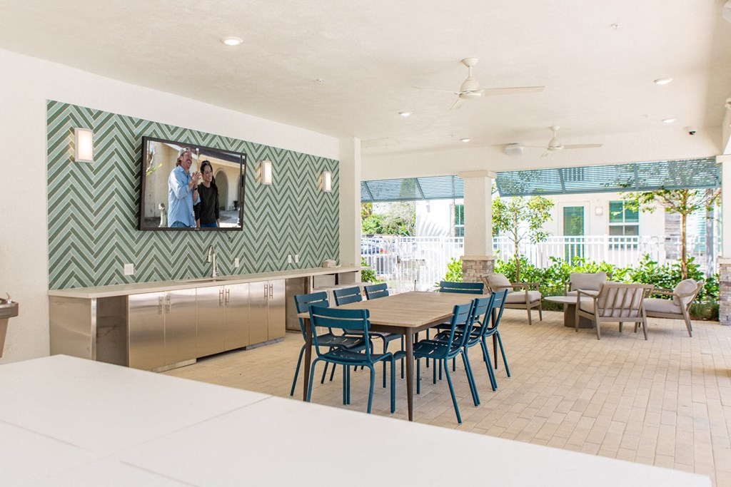 a dining room with a table and chairs and a tv on the wall