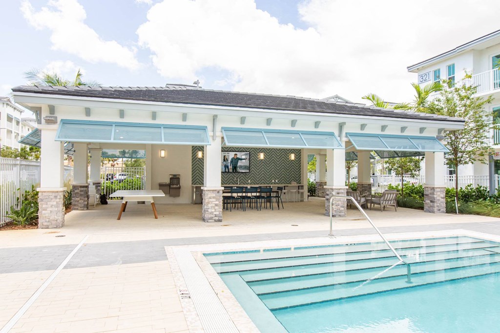 the pool and covered patio of a house with a pool