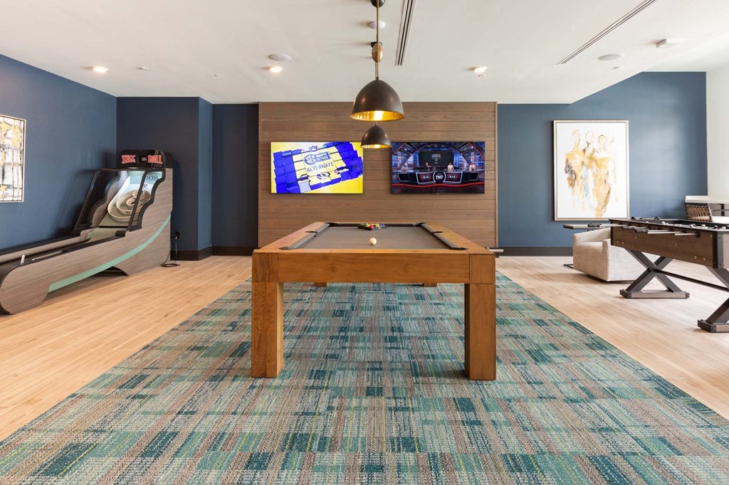 a games room with a pool table and video games