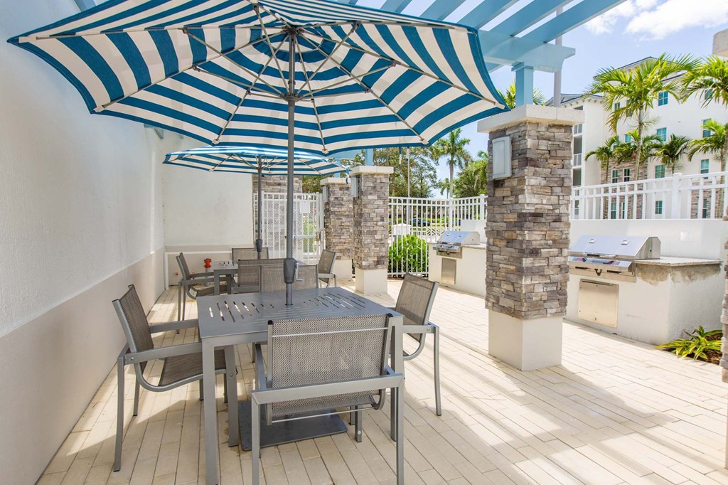a patio with a table and chairs under an umbrella