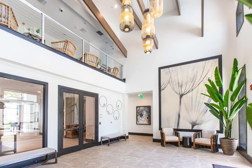 a lobby with a large potted plant and a large glass door