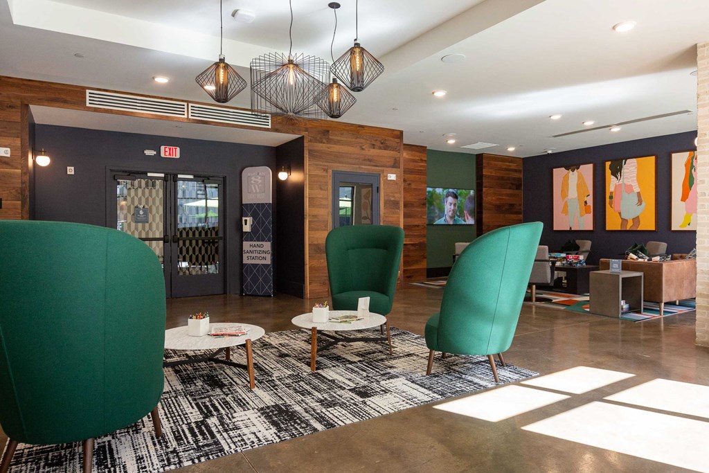 a lobby with green chairs and a rug