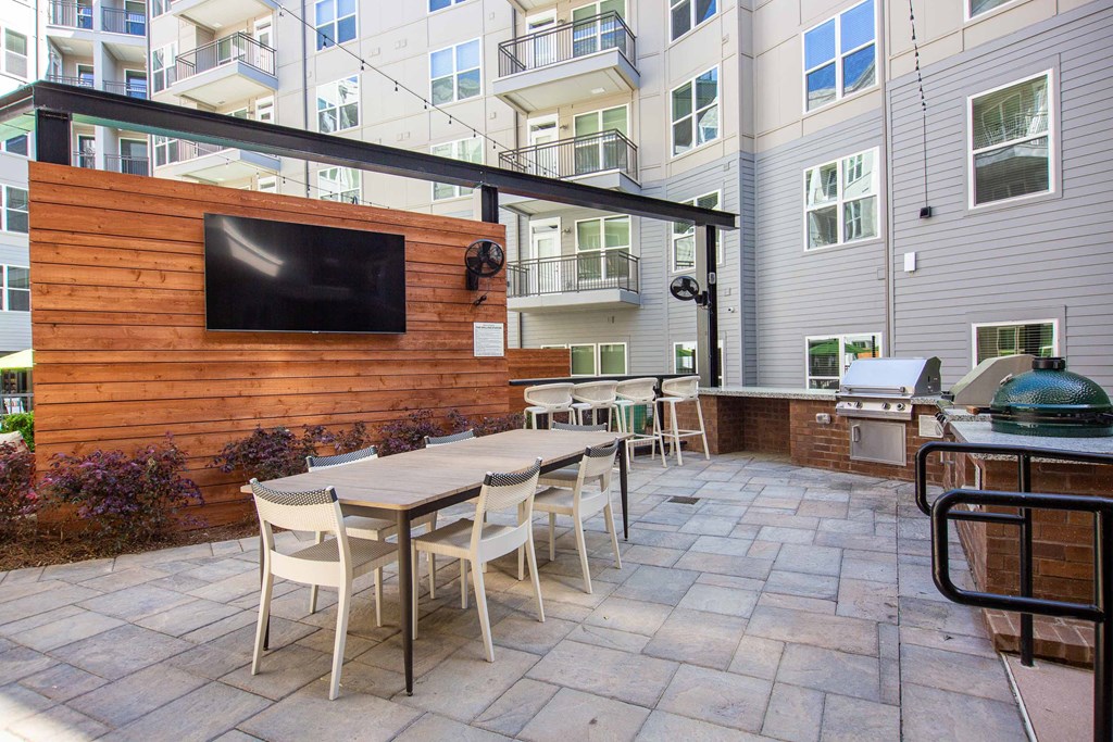 a patio with a wooden wall and a table with chairs