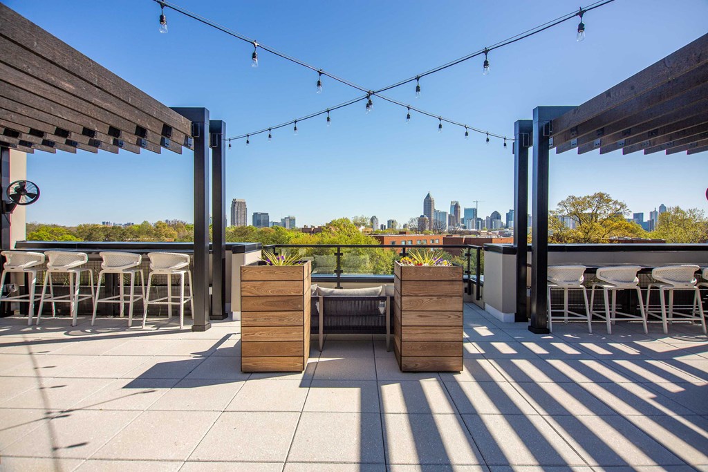 a rooftop terrace with tables and chairs and a view of the city