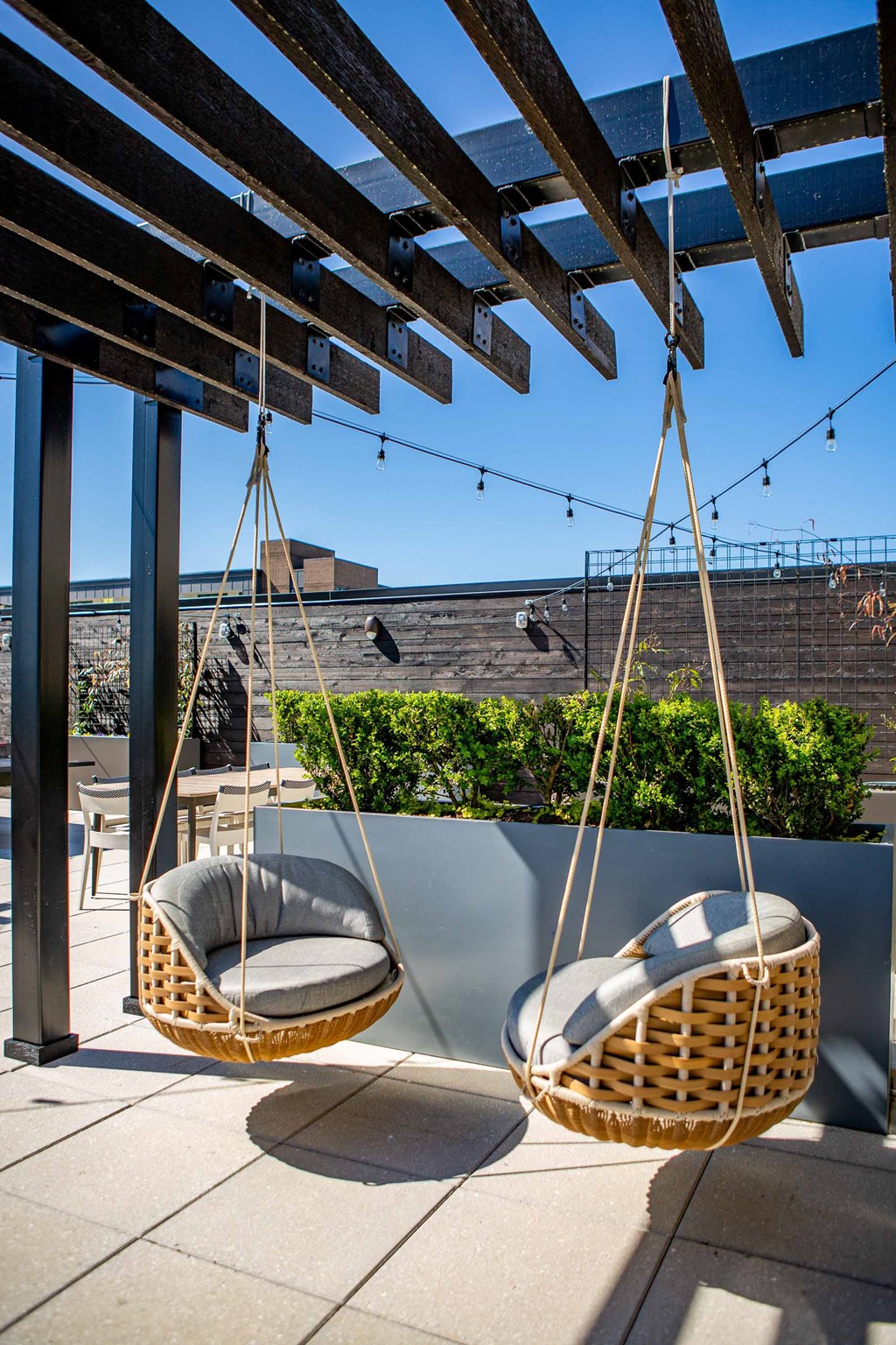 two hanging chairs on a balcony with a blue sky