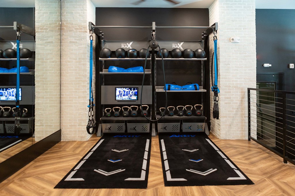 a gym with two racks of weights and mats on the floor