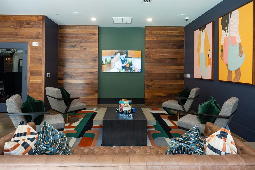 a living room with a couch and chairs and a tv