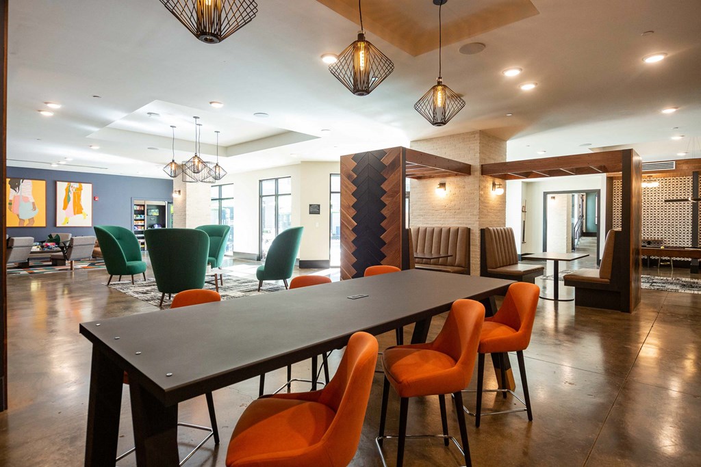 a long table with orange chairs in a lobby