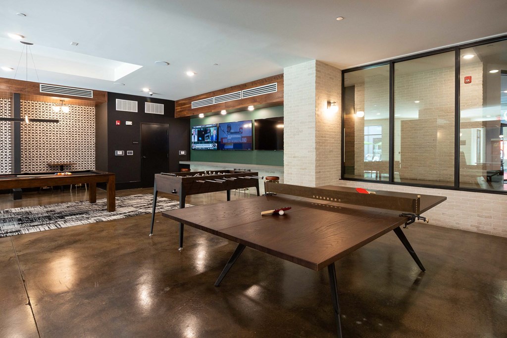 a game room with a ping pong table and a television