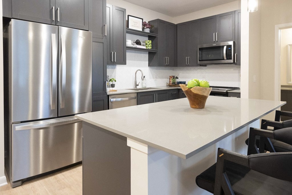 a kitchen with stainless steel appliances and a large white counter top