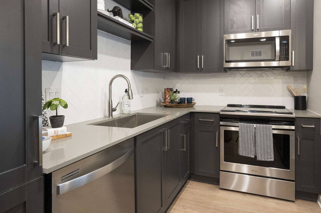 a kitchen with stainless steel appliances and gray cabinets