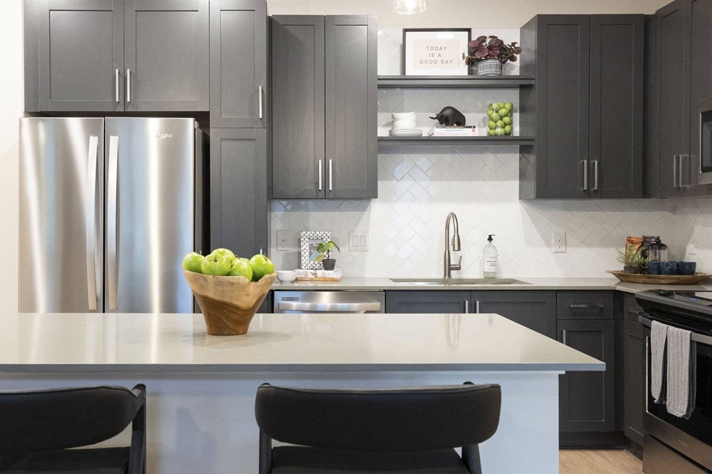 a kitchen with gray cabinets and a white counter top