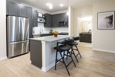 a kitchen with stainless steel appliances and a island with three stools