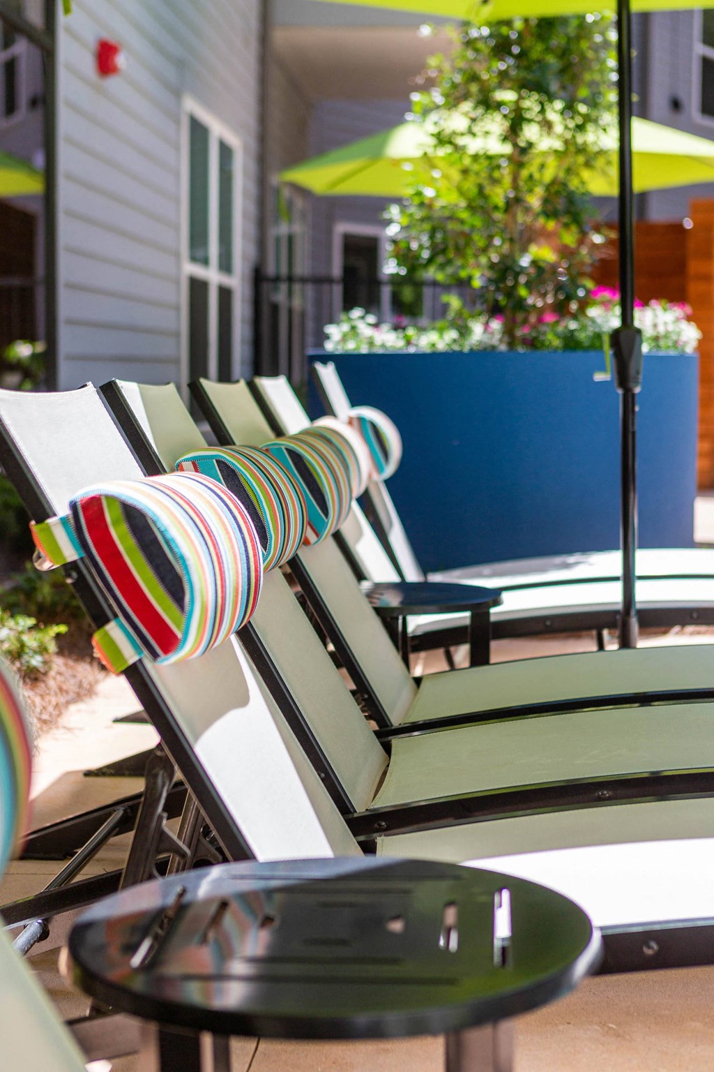 a row of patio chairs with striped pillows