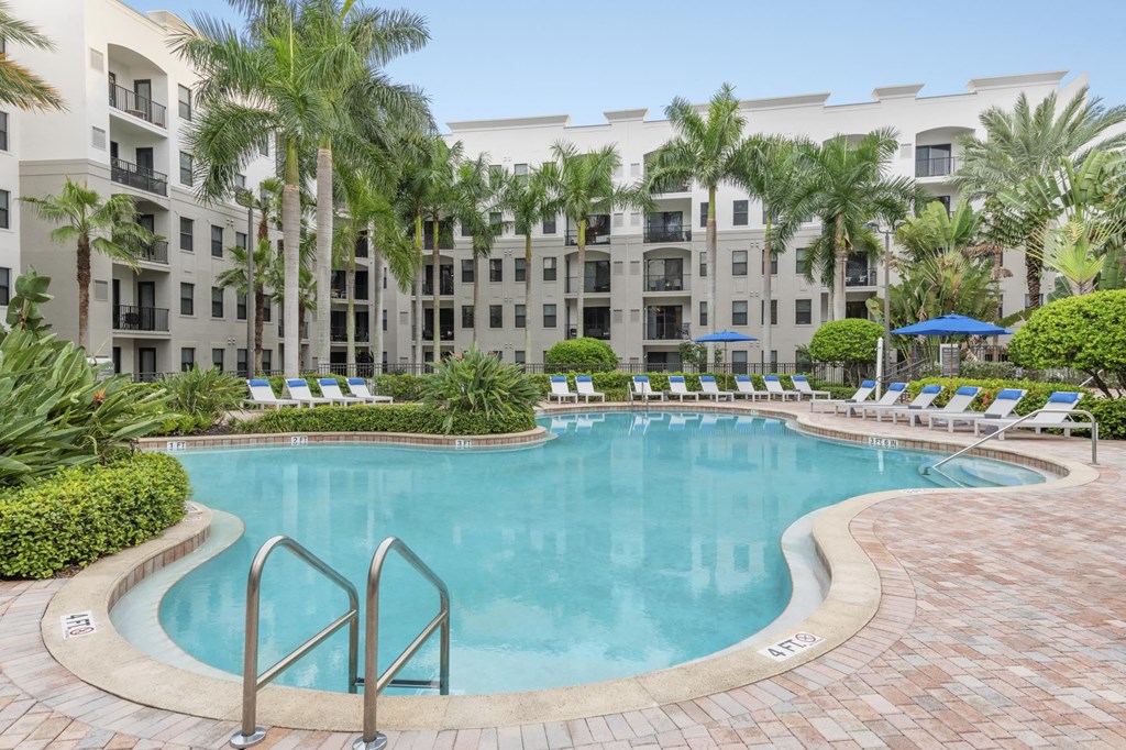 a large swimming pool in front of an apartment building