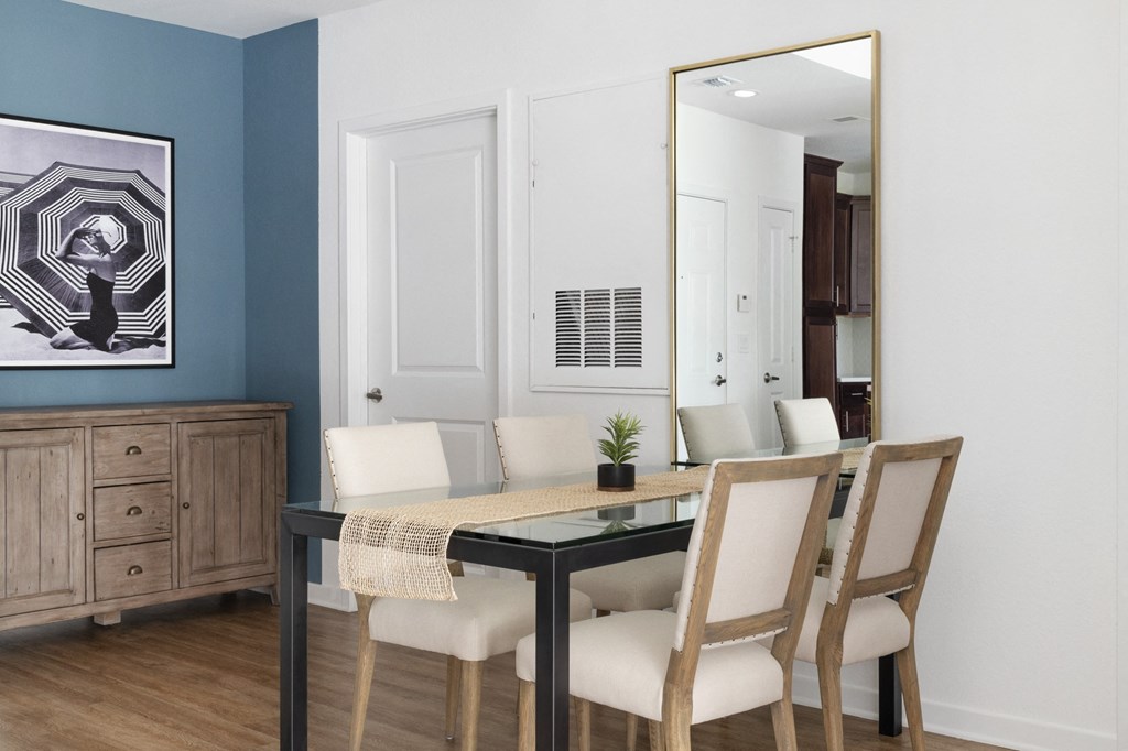 a dining room with a table and chairs and a mirror