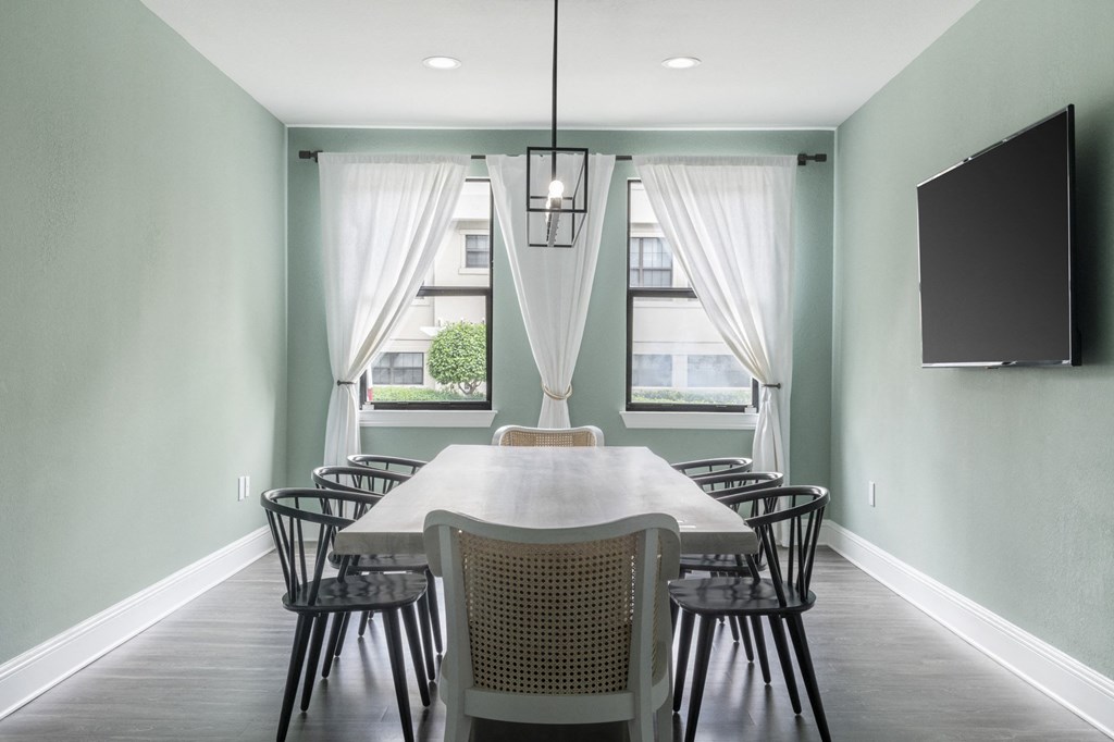 a dining room with a table and chairs and a tv
