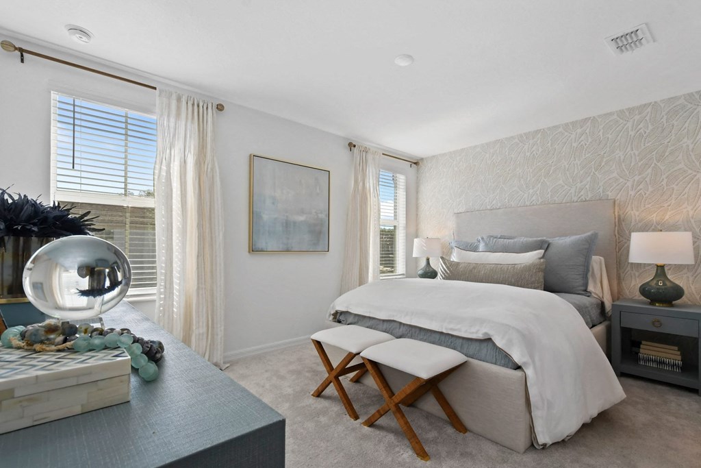 a bedroom with a bed and a table with two chairs