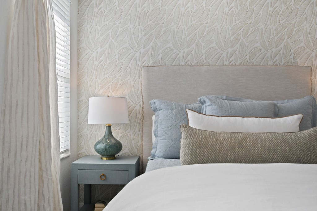 a bedroom with a bed and a nightstand with a lamp