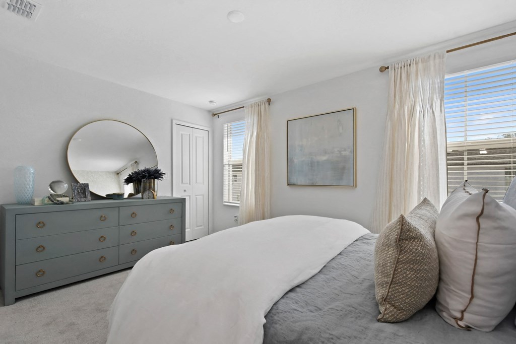 a bedroom with a bed and a dresser with a mirror