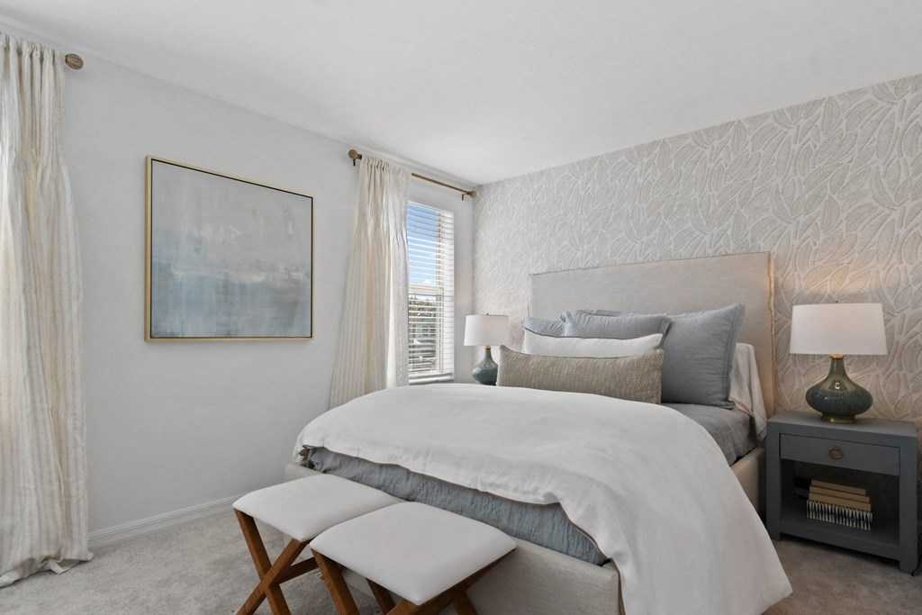 a bedroom with a bed and two stools