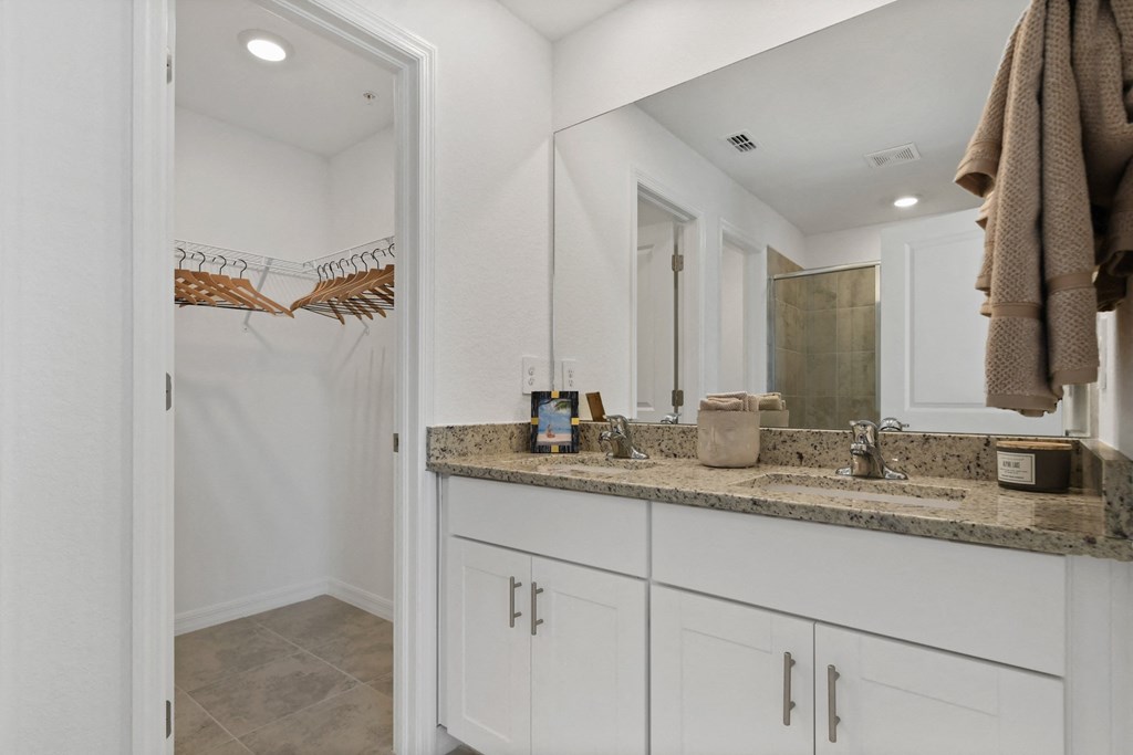 a bathroom with white cabinets and a sink and a mirror