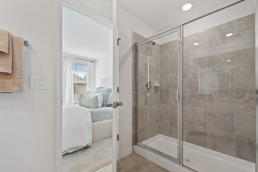 a bathroom with a shower and a bed in it
