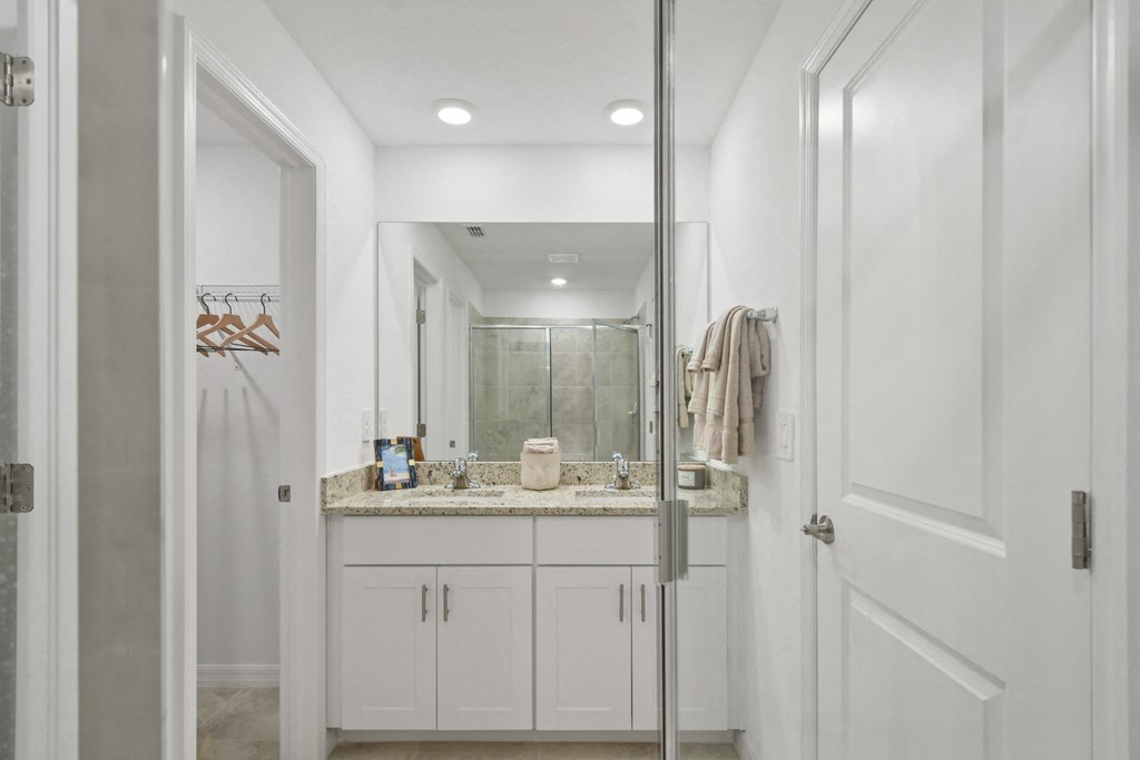 a white bathroom with a sink and a shower