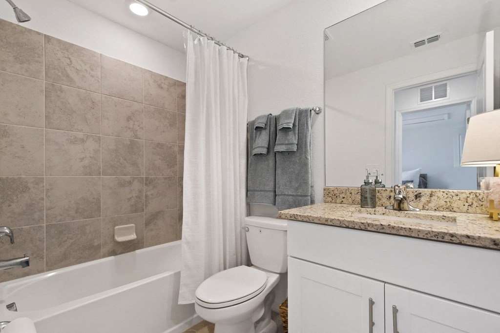 a bathroom with a shower and a toilet and a sink