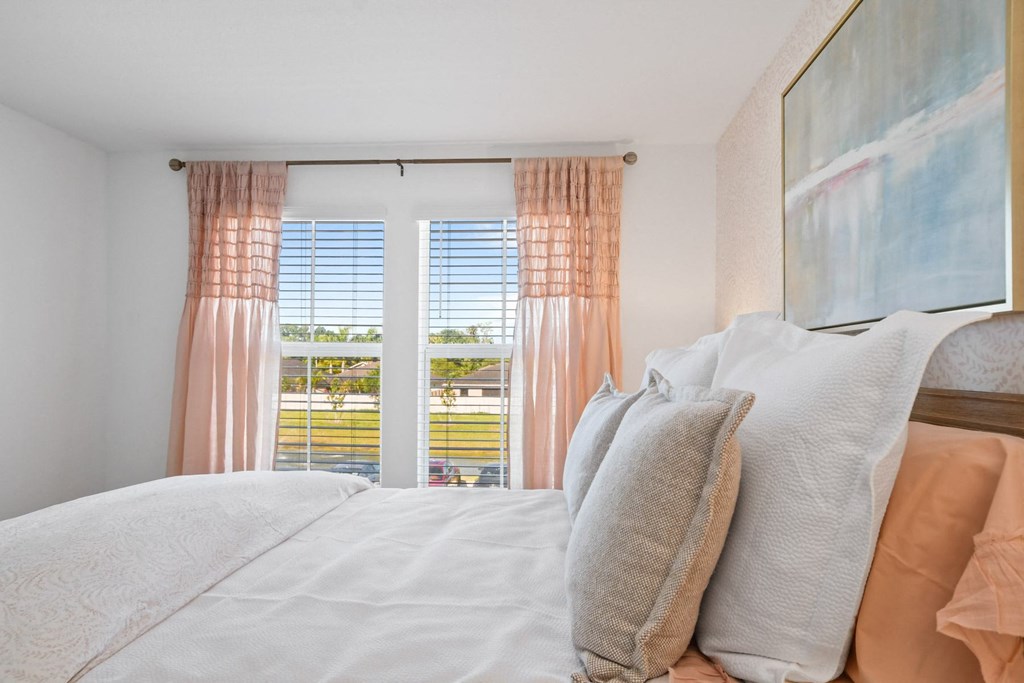 a bedroom with a bed and a window with curtains