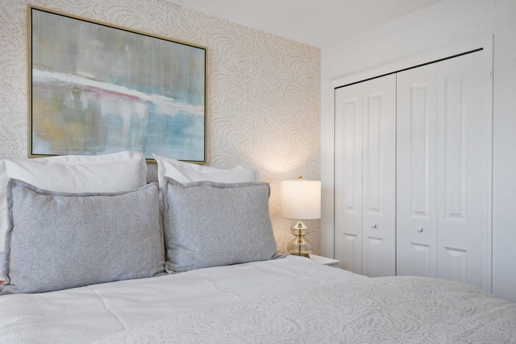 a bedroom with a bed and a painting on the wall