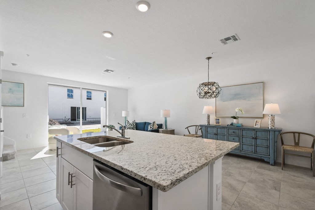 a kitchen island with a sink and a view of a living room