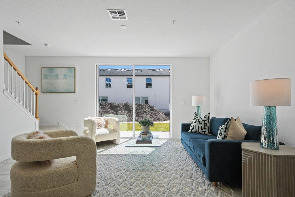 a living room with a blue couch and chairs and a large window