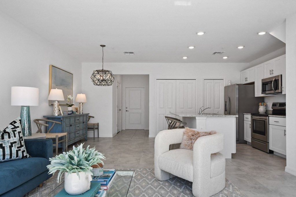 a living room with a couch and a chair and a kitchen