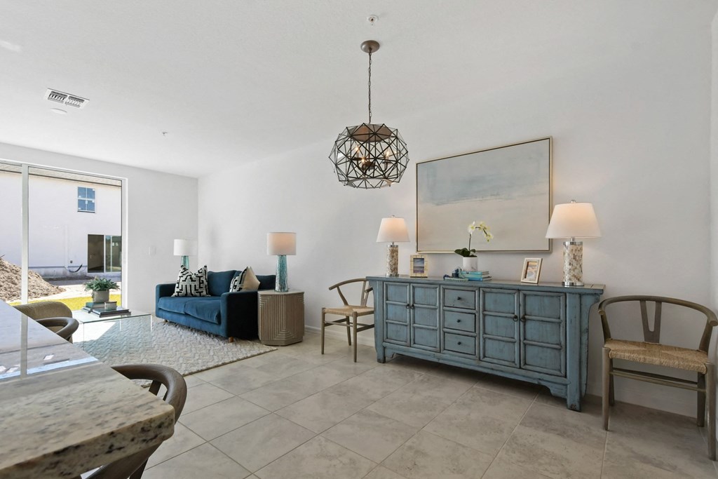 a living room with a blue dresser and a couch and a dining room table