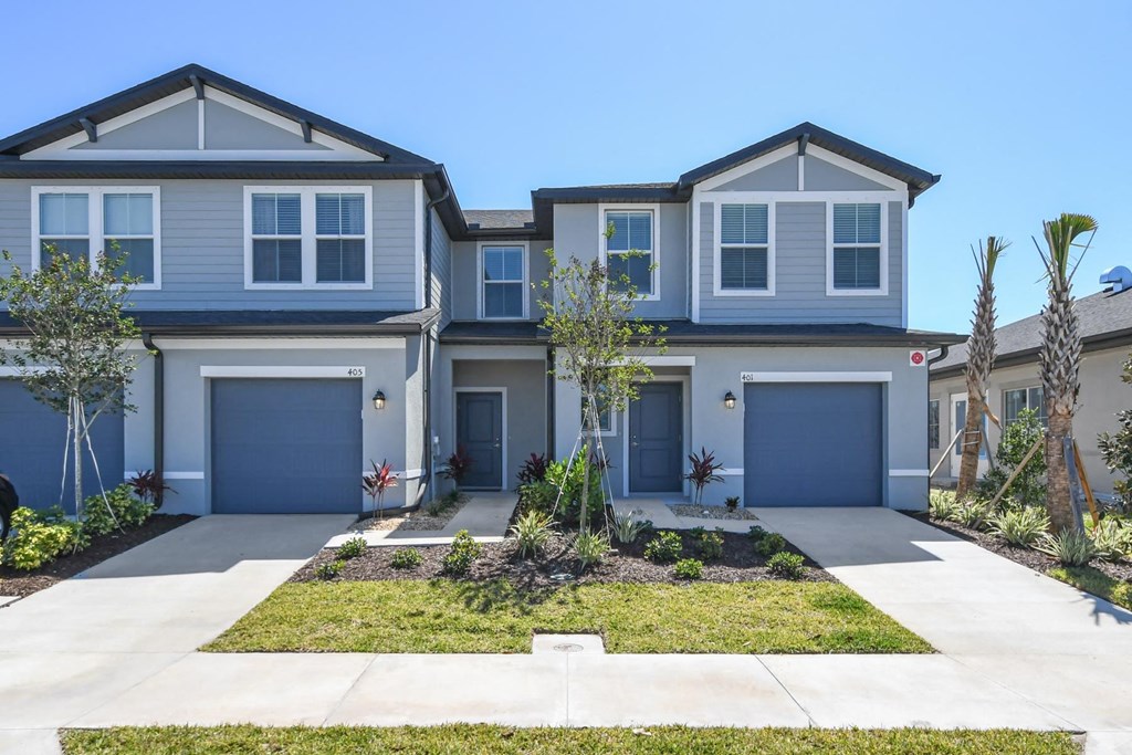 a blue house with blue doors and a lawn