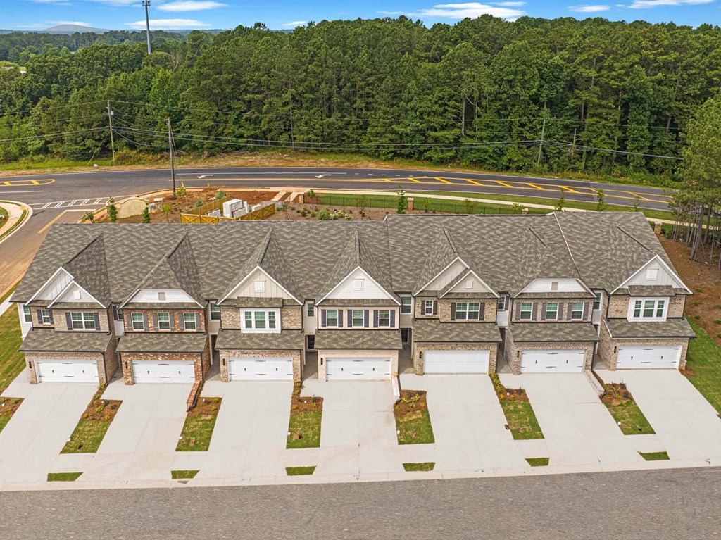 an aerial view of a house with garage doors and a parking lot