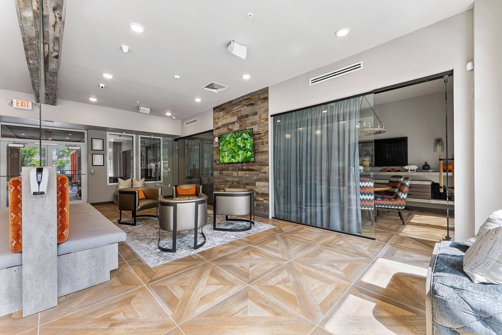 a lobby with a couch and chairs and a tv on the wall